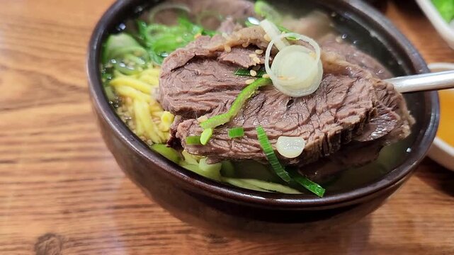 Close-up of traditional Korean short rib soup Galbitang with egg garnish and meat