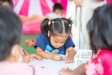 Adorable little asian preschool girl enjoy drawing pencil color paint on paper