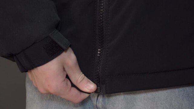 man's hands buttoning a black jacket, Man getting ready to go out, buttoning his jacket