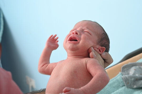 Infant in his father's arms in a moment of tenderness
