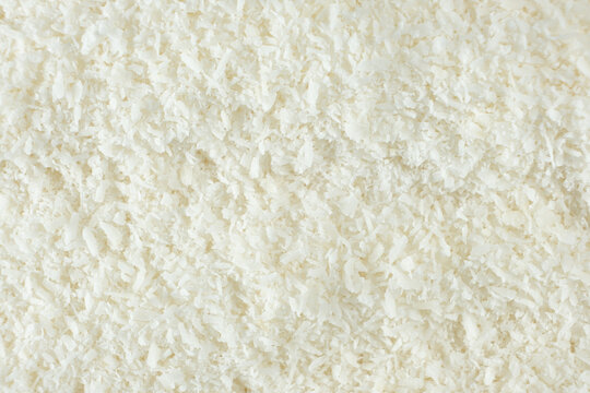 Background texture of white desiccated coconut flakes top view