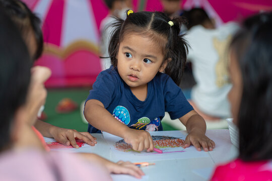Adorable little asian preschool girl enjoy drawing pencil color paint on paper