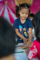 Adorable little asian preschool girl enjoy drawing pencil color paint on paper