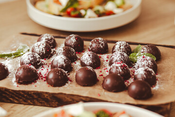 Close-up of homemade chocolate truffles dusted with powdered sugar and mint leaves