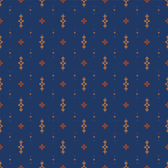 Small pixel diamonds and crosses arranged in a calm grid over a deep blue background. Orange accents create a balanced folk geometric surface suitable for textile and pattern use. © Prayma