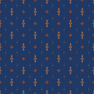 Small pixel diamonds and crosses arranged in a calm grid over a deep blue background. Orange accents create a balanced folk geometric surface suitable for textile and pattern use.