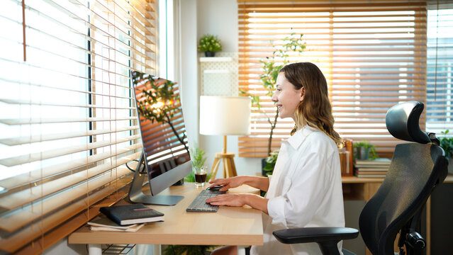Creative website designer woman at computer or desktop pc working on internet SEO for digital marketing agency. Remote, work from home girl or freelance copywriter employee of online tech company