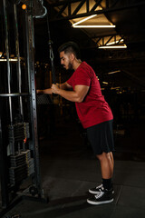Athletic Man Performing Triceps Pushdown Exercise on Cable Machine