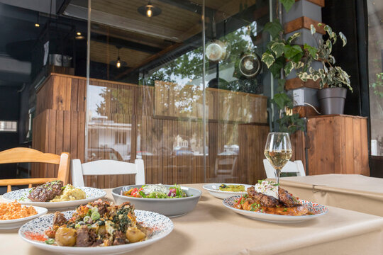 View of a table at a greek tavern with various food. Soft focus