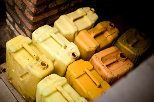 Stacked plastic jerry cans in various shades of yellow and orange. Kigali, Rwanda