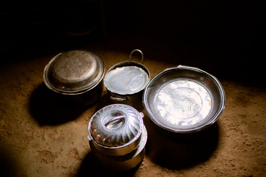 Vintage metal plates and cups on a rustic wooden surface with soft light. Kigali, Rwanda