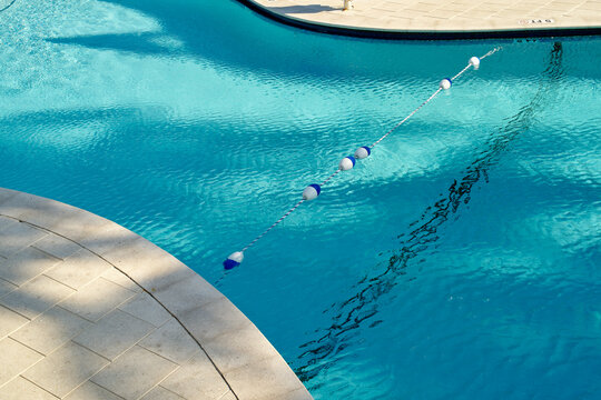 Refreshing outdoor swimming pool with clear blue water and floating lane divider. Miami, Florida, USA