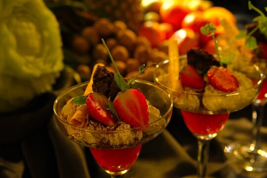 Delicious dessert in glass. Red jelly, straweberry slices, whipeed cream, choco cookies. Ideal for food background