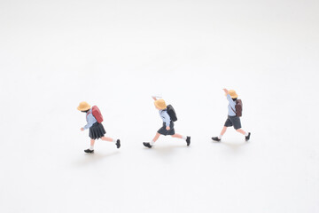 Fototapeta premium Miniature students walk forward in neat uniform line