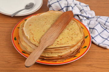 Assiette de cr&ecirc;pes bretonnes avec une spatule en bois en gros plan