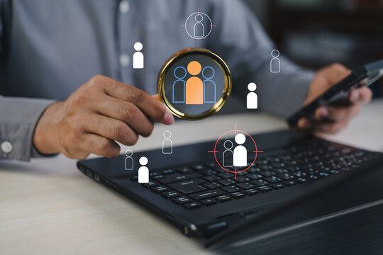 Business professional using laptop and smartphone with people analytics and user targeting interface,visualizing identity data,profile management,digital intelligence for modern business strategy.