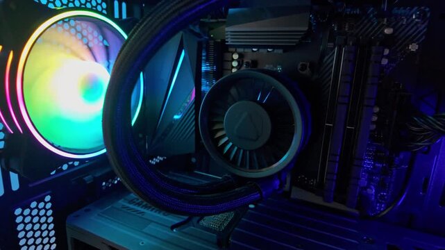 Slow motion pan across gaming pc interior with rgb lighting, liquid cooling system, modern hardware components, and high performance desktop computer technology