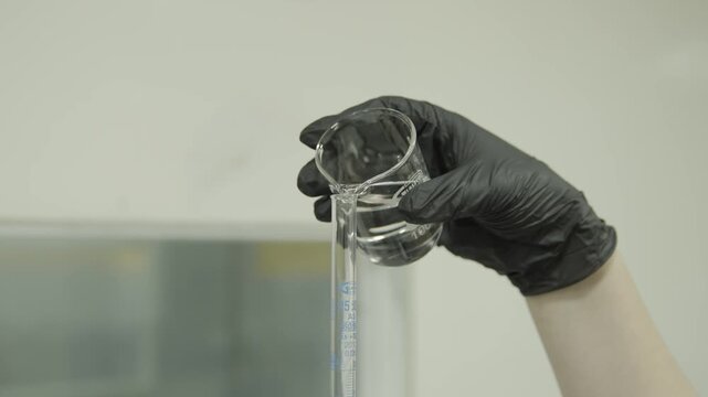 Beaker pouring liquid in tube in laboratory 4k