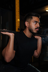 Strong Athletic Man Performing Barbell Back Squat in Modern Gym