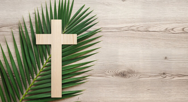 Happy easter sunday greeting with symbolic cross and palm leaves on wooden background