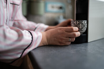 Obraz premium Person making morning coffee with capsule espresso machine