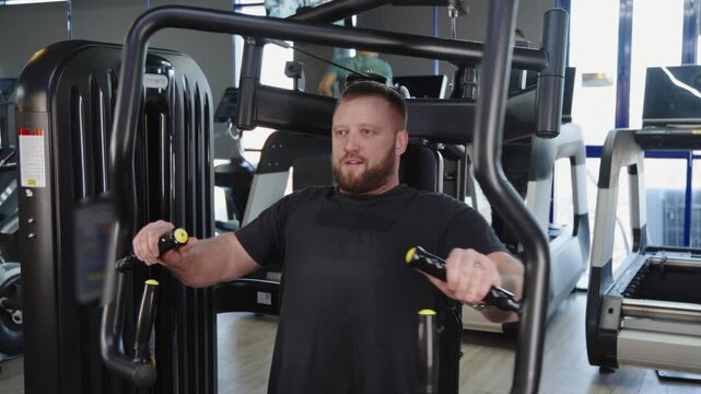 Man performing chest fly exercise on gym machine