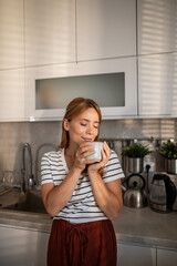 Woman enjoying coffee ritual in morning kitchen