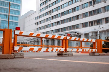 Orange and white warning barrier blocking road entry