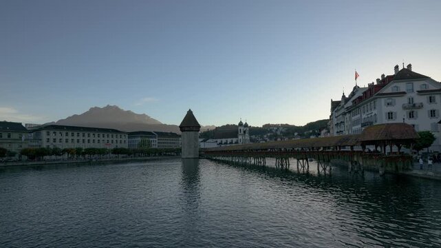 Chapel Bridge and Water Tower reflected in the Reuss River at dusk with Mount Pilatus in the background