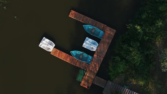 Boats moored at wooden dock experiencing summer leisure