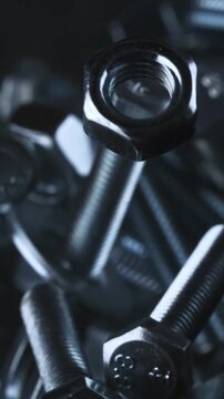 Vertical Macro Shot of Metal Nuts and Bolts Falling Together, Industrial Texture, Strength and Mechanical Concept