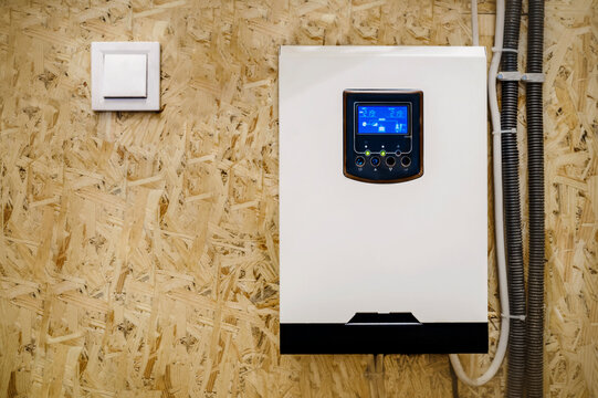 Solar Inverter mounted on Wall with Working Display Screen. Modern Aluminum Alloy Solar Hybrid Inverter and Switch 