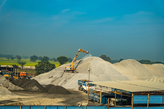 Industrial machinery working at stone crusher fields with river sand and aggregate for construction in India