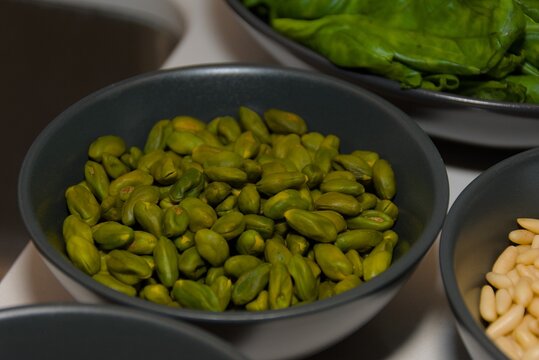 Raw Green Pistachio Kernels in Black Ceramic Bowl