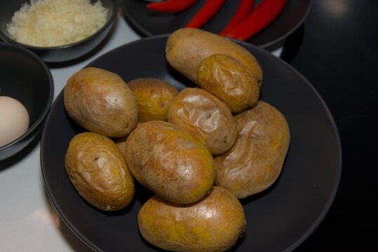 Unpeeled Raw Potatoes in Black Bowl on Kitchen Counter
