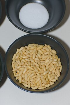 Raw Pine Nuts and Fine Sea Salt in Black Bowls