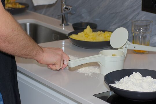Ricing Cooked Potatoes Onto Flour for Gnocchi Preparation