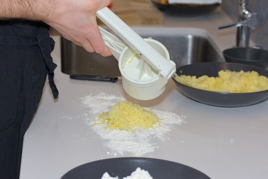 Ricing Cooked Potatoes Onto Flour for Gnocchi Preparation