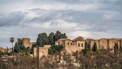 Ancient Ruins of Gibralfaro castle on a Green Hill Under a cloudy Sky, Malaga, Spain