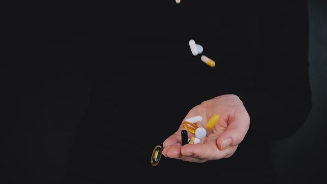 Adult woman pouring pills into her hand in slow motion, representing health, pharmacy, dietary supplements, and wellness concept.