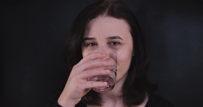 Adult woman taking a pill, symbolizing health, self-care, wellness, and dietary supplements in a responsible daily routine.