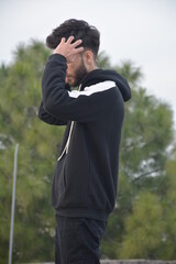 Athletic man in sporty hooded sweatshirt standing