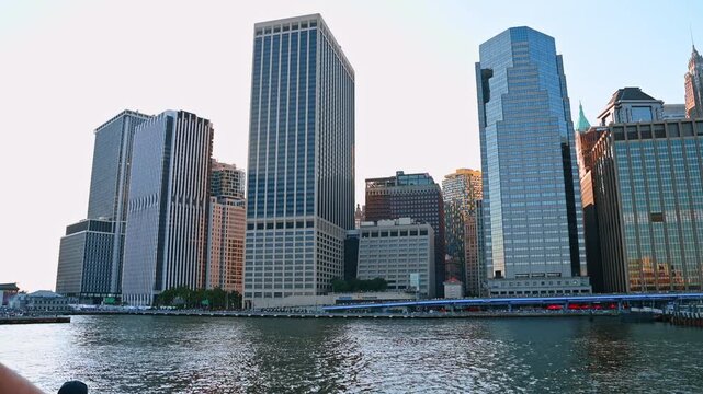 Modern high-rises of modern city at the waterfront of the river. Low angle view at the skyline of New York, USA from the waterscape.