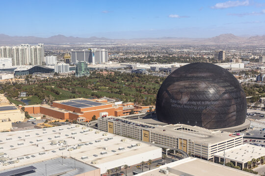Las Vegas, Nevada, USA - March 3rd, 2024: High angle view MSG Sphere building foreground expansive Las Vegas city suburbs mountains background