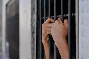 prisoner's hands behind bars, prison