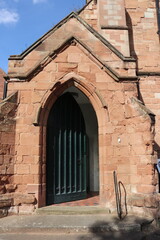 Fototapeta premium Stone arched doorway with closed metal gate on historic building exterior. Architectural detail showing symmetry, texture, and traditional masonry design.