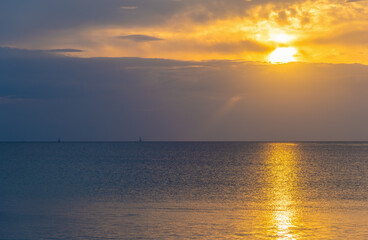 Sunset Over the Sea with Distant Boats on the Horizon