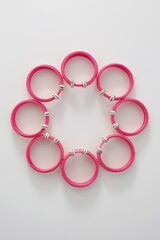 A collection of pink and white beaded bangles arranged in a circular pattern.