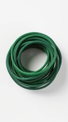 A coiled green rope lying on a plain white background surface.