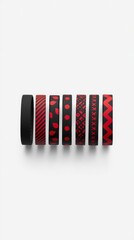 Assorted black and red patterned cylindrical objects arranged in a row